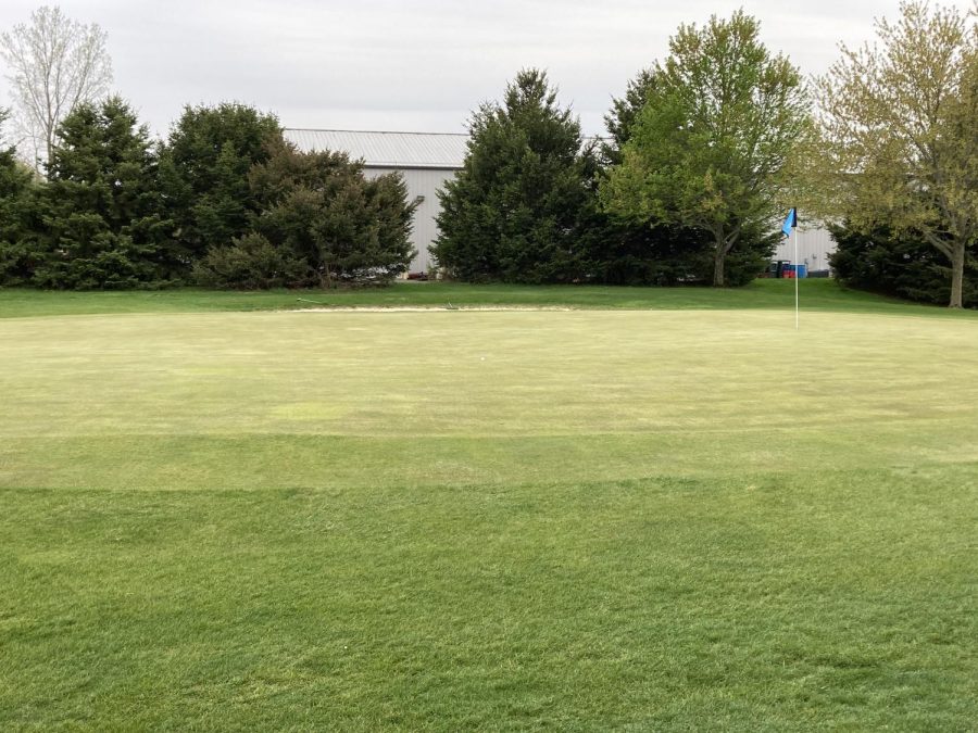 A lone golf flag on an empty field