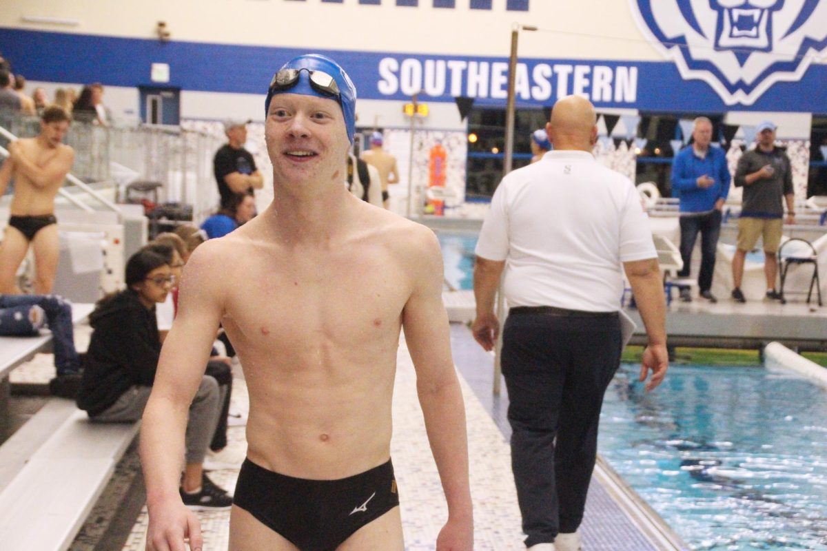 Junior Jacob Frey smiles at crowd following his race. Frey had just won the 100 backstroke from lane 8. 
