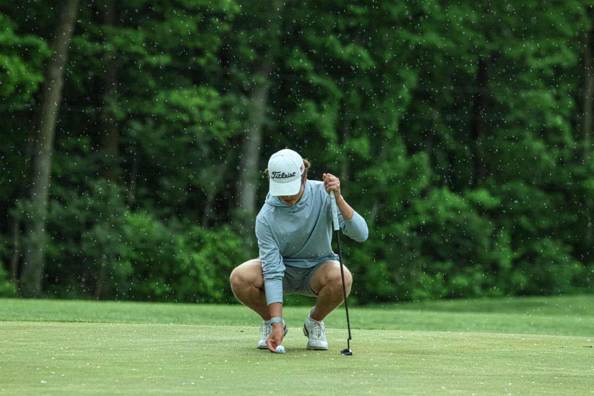During the rain Freshman, Brody Colburn sets the ball down to putt at Fall Creek Golf Club on May 9th, 2024